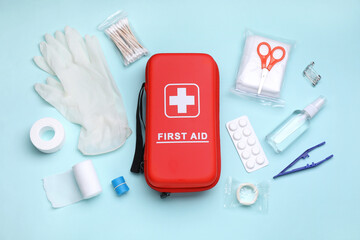 Flat lay composition with first aid kit on light blue background