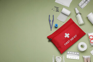 Flat lay composition with first aid kit on light green background, space for text