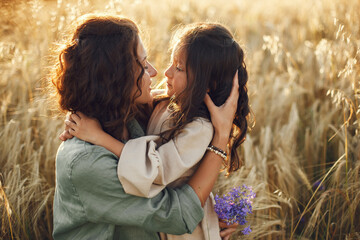 Mother with daughter playing in a summer field