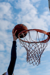 Close-up of a basketball hoop where a tall guy basketball player is scoring a dunk The concept of...