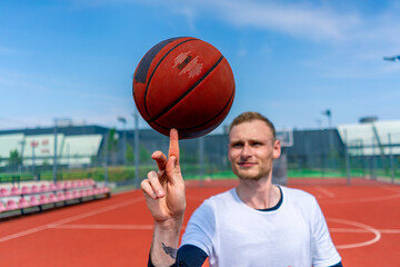 Close-up of a guy basketball player spinning a basketball on his finger showing his basketball freestyle skills 