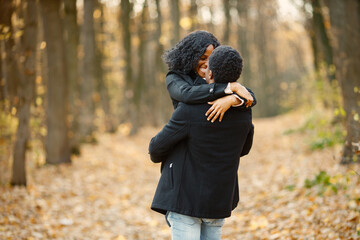 Loving black couple walking in park and enjoying autumn day