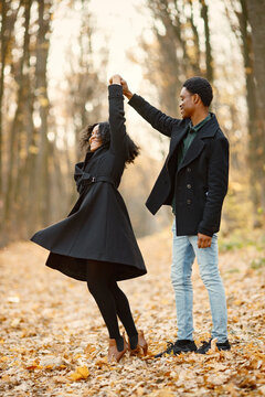 Loving black couple walking in park and enjoying autumn day