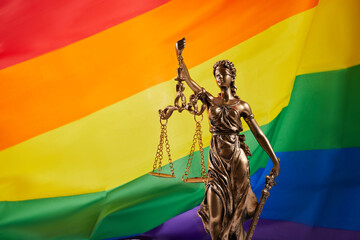 The blindfolded goddess of justice Themis against the rainbow flag of LGBT. LGBT rights and law.