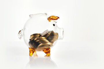 Transparent piggy bank with money coins.