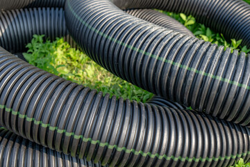 Black storm water underdrain pipe used to mitigation ground water.  Abstract rounded shape. - obrazy, fototapety, plakaty
