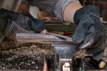 Hand craftsman uses rasp decorate to polish the handle wood hammer handle - obrazy, fototapety, plakaty