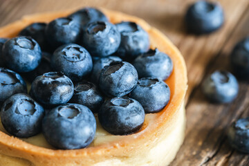 Blueberry tart on a wooden background, close up.