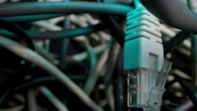 The camera delves into the thicket of network cables and more. Tangled cables, messy computer problems.