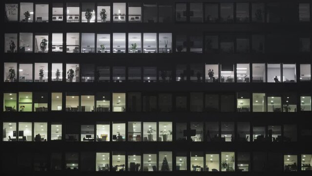 Lights switched off in the building's offices at the end of the working hours, timelapse