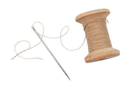 Old wooden spool of thread and needle on a white background. Sewing accessories