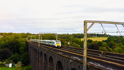 UK Commuter Train Travelling Across a Viaduct at Sunset. 