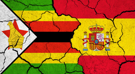 Flags of Zimbabwe and Spain on cracked surface - politics, relationship concept