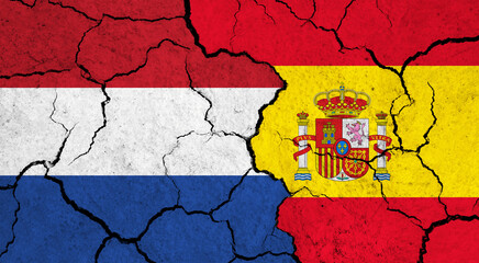 Flags of Netherlands and Spain on cracked surface - politics, relationship concept