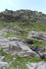 A rocky mountain with grass on it
