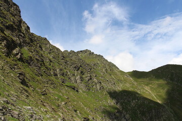 A mountain with a blue sky and clouds