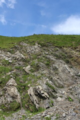 A rocky hill with grass and rocks