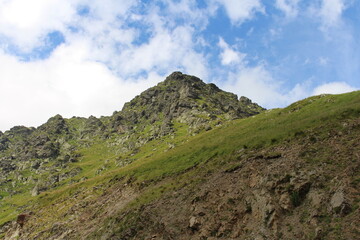 Fototapeta na wymiar A green hill with rocks and grass