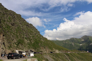 Cars parked cars on a road next to a mountain