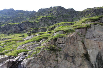 A rocky mountain with grass on it
