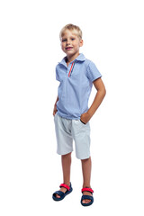 A laughing boy in a shirt and shorts stands with his hands in his pockets. Isolated on white background. Vertical.