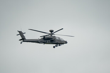British army AH-64E Boeing Apache Attack helicopter in level flight action, Wiltshire UK