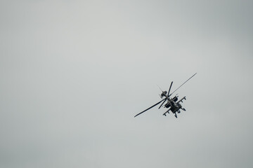 British army AH-64E Boeing Apache Attack helicopter banking hard in flight action, Wiltshire UK