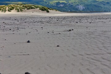beach with dunes and mountains in the background in Barmouth, UK