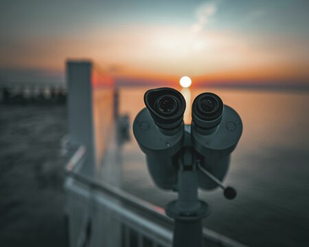 Close up of binoculars on a sunset sky background