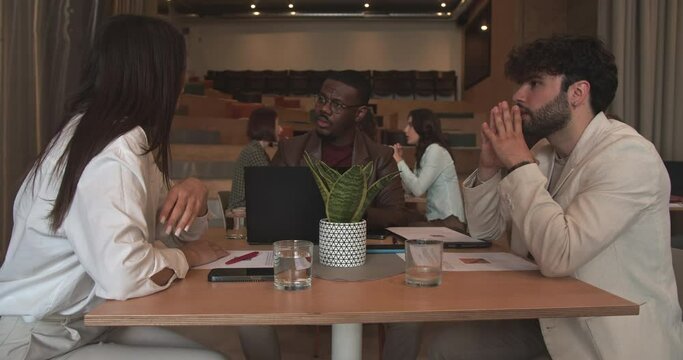 Multiracial business people working on a business plan for the start up company at a cafe bar, camera trucking