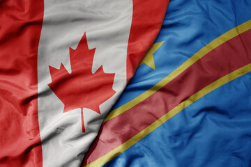 big waving realistic national colorful flag of canada and national flag of democratic republic of the congo .