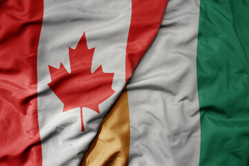 big waving realistic national colorful flag of canada and national flag of cote divoire .