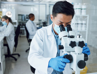 Microscope, science and asian man with mask in laboratory to review virus particles, medical test...