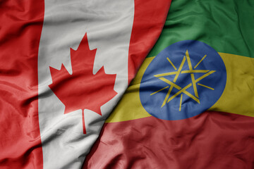 big waving realistic national colorful flag of canada and national flag of ethiopia .