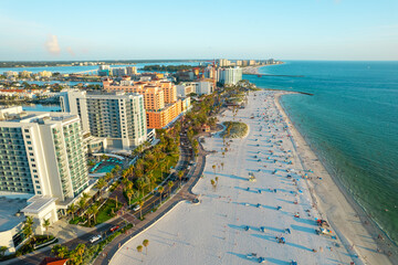 Fototapeta premium Florida. Panorama of Clearwater Beach FL. Summer vacations in Florida. Beautiful View on Hotels and Resorts on Island. Sunset time. Ocean water. American Coast. Shore Gulf of Mexico. Aerial view