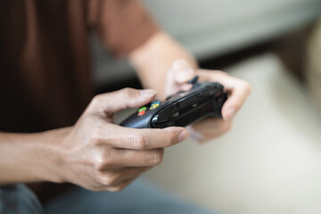 Young Asian man gamer controller video console playing holding hobby playful Online Video Game enjoyment eSport Cyber Games Internet. © Charlie's