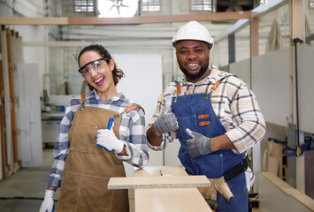 Portrait of a team of professional carpenters, men and women smiling happily in the design of furniture handicrafts in the factory.