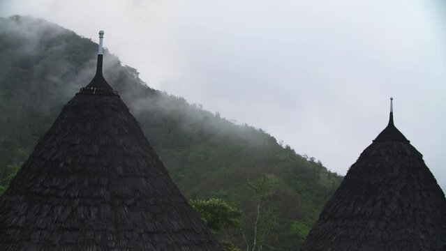 The roof of a traditional house in Wae Rebo Indonesia has fog in the morning