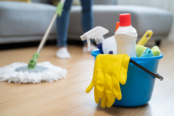 happy Female housekeeper service worker mopping living room floor by mop and cleaner product to...
