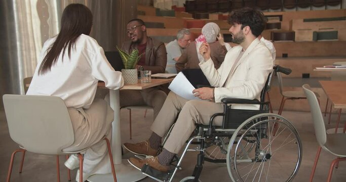 People diverse being inclusive for their disabled colleague in wheelchair
