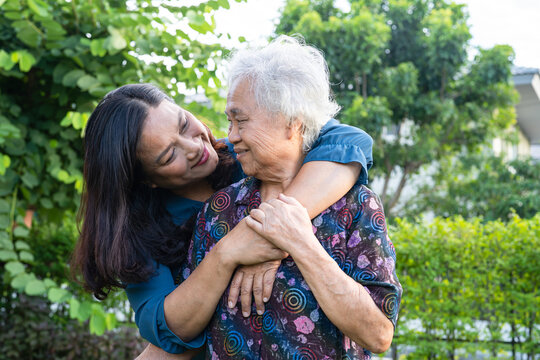 Asian elderly woman hug with her daughter with love, care, help, encourage and empathy at park, healthy strong medical concept.
