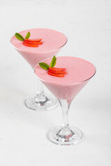 Strawberry cream jelly, Panna Cotta, decorated with fresh strawberry slices, in a martini glass. White background