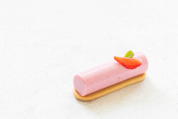 Strawberry cream dessert bar on cookies. Decorated with fresh strawberry slice. White background. Copy space