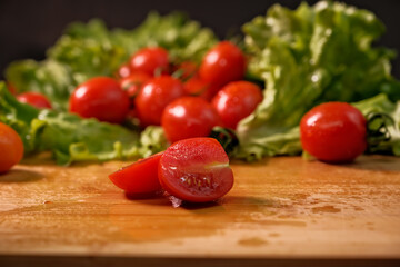 red tomatoes on a branch. water drops. close-up.Leaves of lettuce. knife