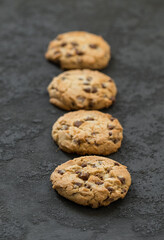 Vegan Round Cookies with pieces of milk chocolate. Dark grey background