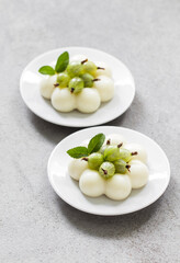 Gooseberry cream pudding, Panna Cotta in the shape of truffles, decorated with fresh gooseberry. On a plate. White background. Top view
