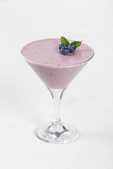 Blueberry cream jelly, Panna Cotta, decorated with fresh blueberry , in a martini glass. White background