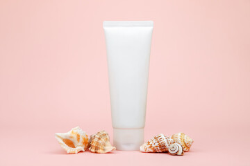 cosmetic cream tube, sea shells on pink background. mockup, skincare product blank plastic package. lotion, balsam, toothpaste, lubricant, cleanser, moisturizer. white bottle