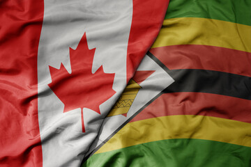 big waving realistic national colorful flag of canada and national flag of zimbabwe .