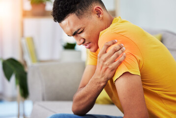 Man, sofa and shoulder pain in home, massage and relief, stress or injury in living room. Health,...